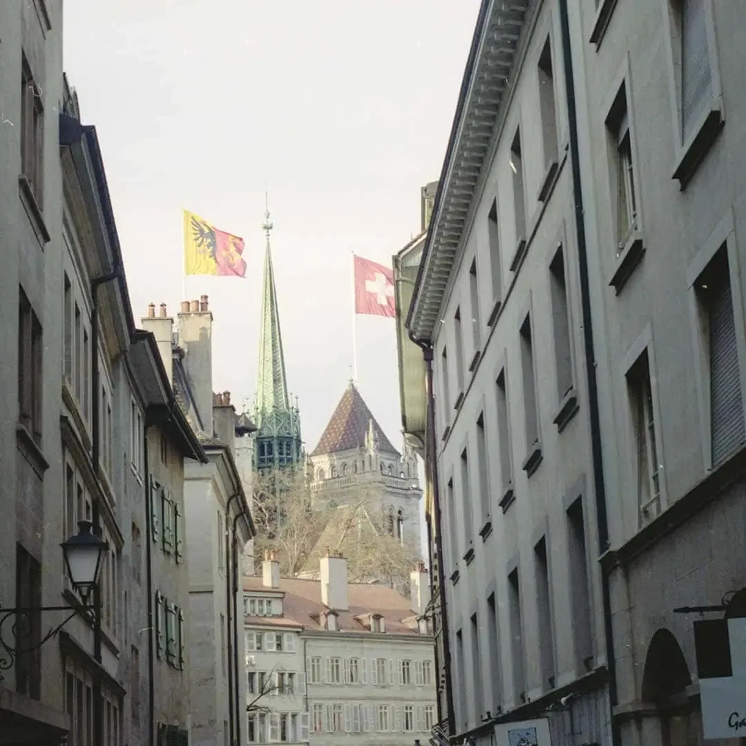 Ruelle de la vieille ville de Genève, drapeaux genevois et suisse devant la cathédrale