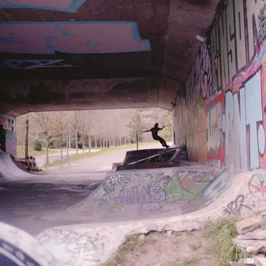Skateur en l’air dans un skatepark couvert de graffitis