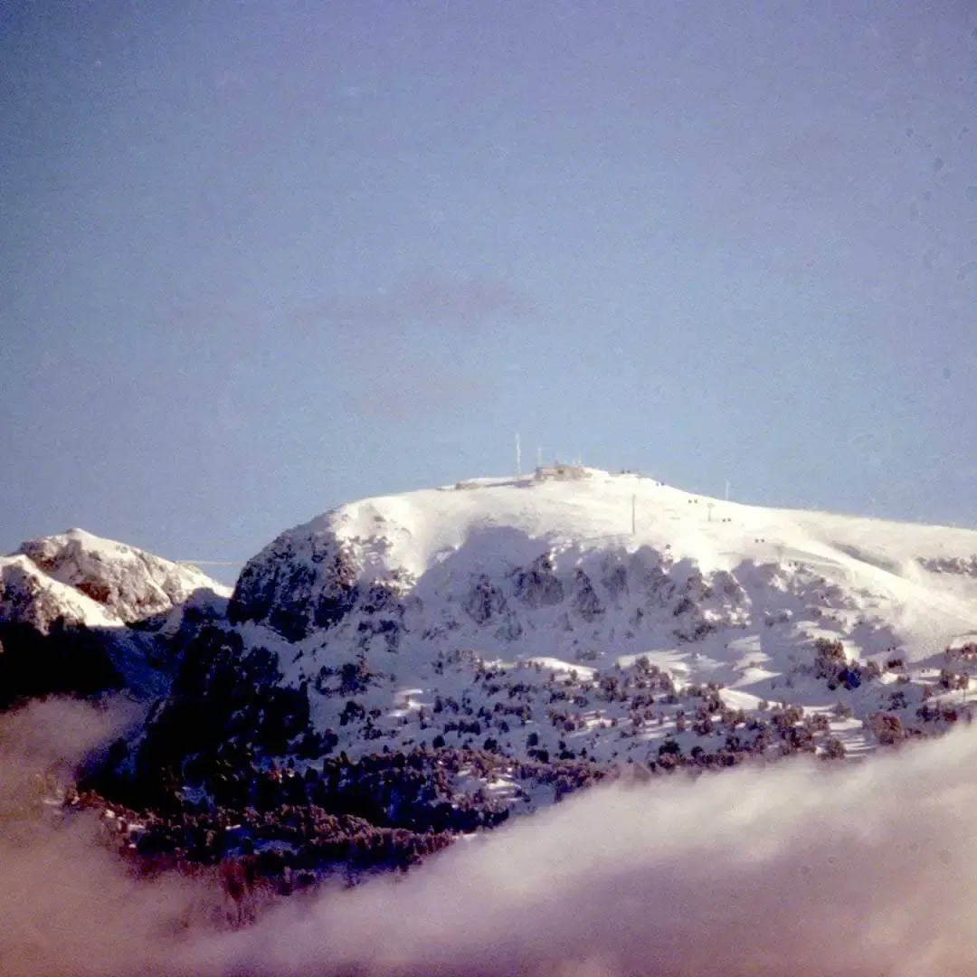 Sommet enneigé au-dessus d’une mer de nuages